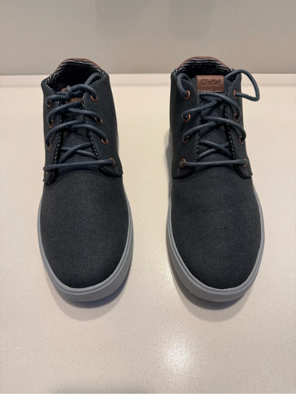 Brand New OluKai Men's Charcoal Gray Canvas Chukka Boots with Light Gray Sole.